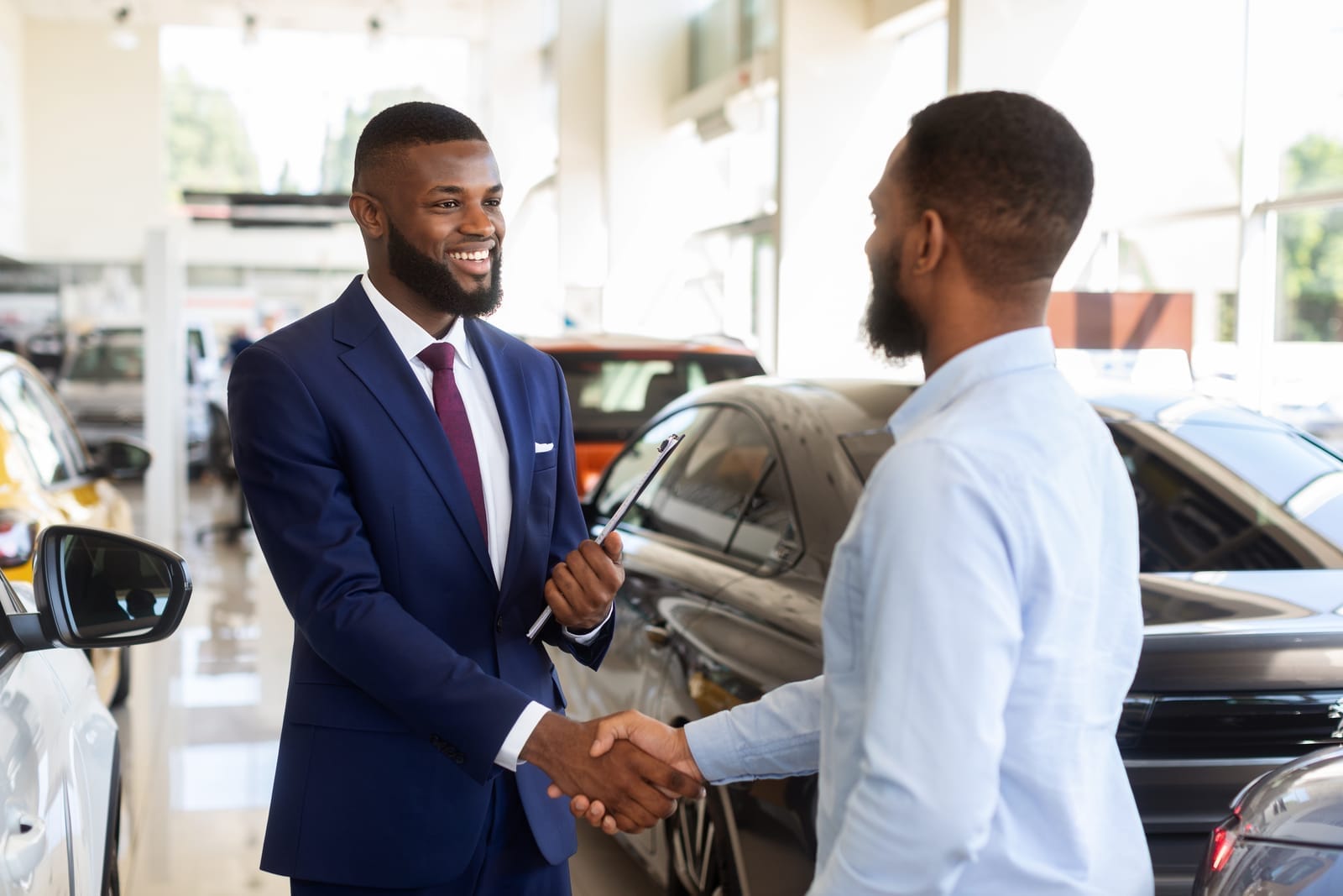 Customer shaking hands with a car dealer inside a showroom